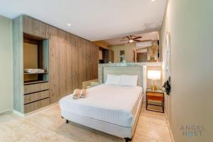 una camera da letto con un letto con due scarpe sopra di Sunlit Studio 4 Blks from 5th Ave with Pools & Gym a Playa del Carmen