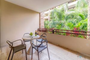un balcone con tavolo e sedie e una grande finestra di Sunlit Studio 4 Blks from 5th Ave with Pools & Gym a Playa del Carmen