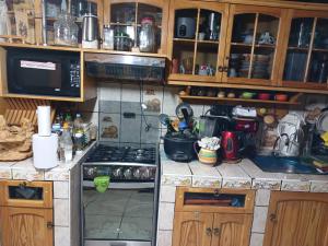 a kitchen with a stove and a microwave at Depa amoblado Samana Cruz in Cajamarca