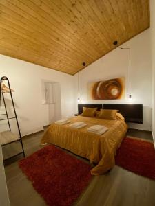 a bedroom with a large bed with a wooden ceiling at Casa Primavera in Alcoutim