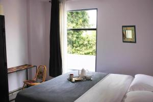 Un dormitorio con una cama y una ventana con una bandeja de comida. en Bed & Chai Guesthouse en Nueva Delhi