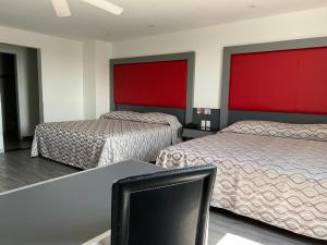 a room with two beds and a desk with a chair at Hotel Atenas Plaza in Mexico City