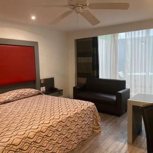 a bedroom with a bed and a chair and a ceiling fan at Hotel Atenas Plaza in Mexico City
