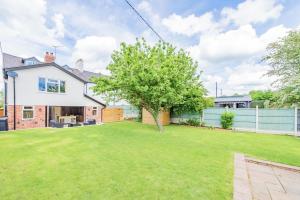 un cortile con un albero e una casa di Mill Cottages Shrewsbury With Hottub a Merrington