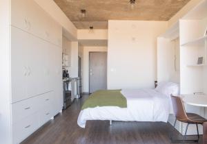 a bedroom with a white bed and a desk at Luxury East Side Studio Apt Near Brady St with Balcony in Milwaukee