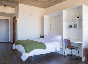 a bedroom with a bed and a desk and a chair at Luxury East Side Studio Apt Near Brady St with Balcony in Milwaukee