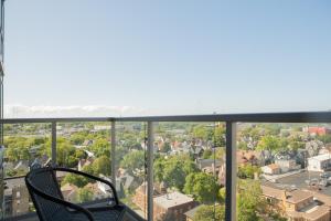 a chair sitting on a balcony overlooking a city at Luxury East Side Studio Apt Near Brady St with Balcony in Milwaukee