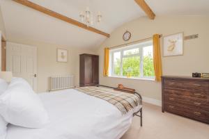 una camera da letto con un letto bianco e una finestra di Mill Cottages Shrewsbury With Hottub a Merrington