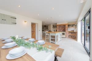 una sala da pranzo con tavolo e piatti bianchi di Mill Cottages Shrewsbury With Hottub a Merrington