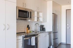 una cucina con lavello e microonde di Luxury Penthouse Apt Near Brady St with Balcony and Lake View a Milwaukee