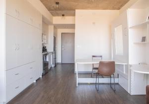 una cucina con armadi bianchi, tavolo e sedia di Luxury Penthouse Apt Near Brady St with Balcony and Lake View a Milwaukee