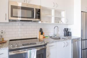 una cucina con lavello e microonde di Luxury Penthouse Apt Near Brady St with Balcony and Lake View a Milwaukee Altre 24 foto