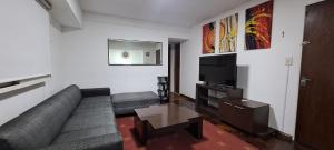 a living room with a couch and a flat screen tv at Hornera Rodi - Lugar estratégico, cochera y pileta in Rosario