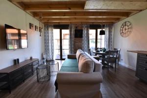 Borowy MłynにあるDomek na Kaszubach 16-1 - Ostoja Bukowoのソファのあるリビングルームとダイニングルーム