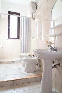 Un baño blanco con lavabo e inodoro. en Jolly Residence, en Marina di Camerota 47 fotos más