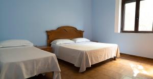 Un dormitorio con dos camas y una ventana. en Jolly Residence, en Marina di Camerota