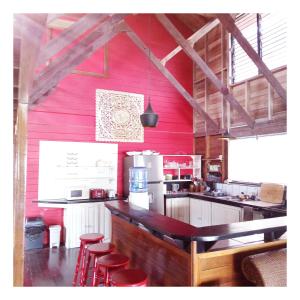 a kitchen with red walls and red stools at Villa Bahia Del Sol in Bocas Town