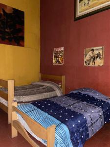 a bedroom with two twin beds and pictures on the wall at Enkanta Guest House in Trujillo +38 photos