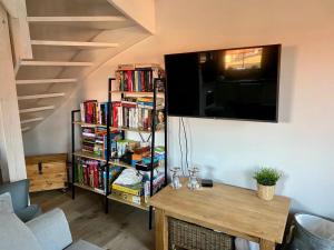 soggiorno con TV e libreria con libri di Domek na Kaszubach 19-1 - Ostoja Bukowo a Borowy Młyn