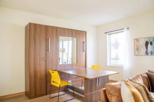 密尔沃基Sunlit Modern Apartment with Balcony的配有木桌和黄色椅子的厨房
