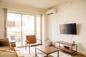 密尔沃基Sunlit Modern Apartment with Balcony的客厅里有一张沙发，墙上有一台电视