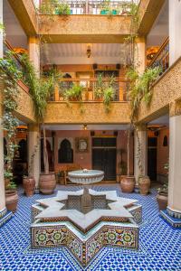 une cour avec une table au milieu d'un bâtiment dans l'établissement Riad Jnane Mogador, à Marrakech