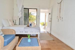 a living room with a bed and a couch at Arena y Mar Beachfront House, El Cuyo by The Spot Rentals in El Cuyo