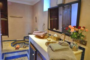 a bathroom with a sink and a large mirror at Riad Adarissa in Fès