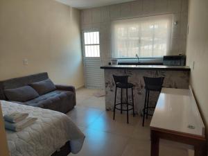 a living room with a couch and a kitchen at Pousada Jaguary in Bragança Paulista
