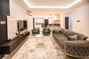 a living room with a couch and a tv at Stylish 2-Bedroom Apartment at East Legon in Ajiringano