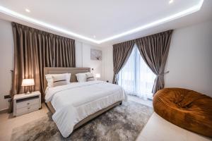 a bedroom with a large bed and a large window at Stylish 2-Bedroom Apartment at East Legon in Ajiringano