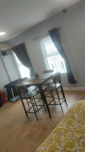 a table and chairs in a room with windows at The OldTown Apartments in Cookstown +32 photos