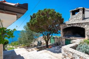 ein Steinhaus mit Blick auf das Meer in der Unterkunft Seaside house for families with children Cove Ramascica, Trogir - 23368 in Marina