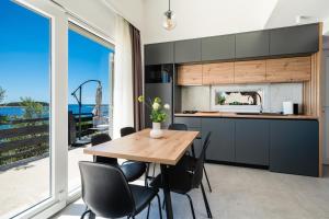 eine Küche mit einem Holztisch und schwarzen Stühlen in der Unterkunft Seaside house for families with children Cove Ramascica, Trogir - 23368 in Marina
