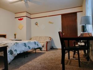 ロートンにあるGolden Sunflower's Apt B1のベッドと椅子と机のある寝室