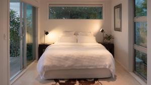 una camera da letto con un letto grande con due finestre di Seascapes Waterfront 2 a Paraparaumu Altre 12 foto