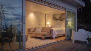a room with a bed and a couch and a window at Seascapes Waterfront 3 in Paraparaumu