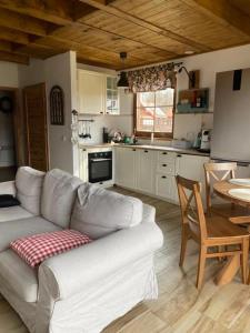 a living room with a couch and a table in a kitchen at Domek na Kaszubach 22-2 - Ostoja Bukowo in Borowy Młyn