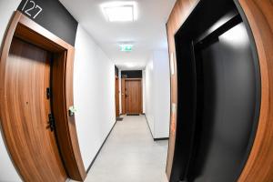 a hallway with two elevators and a hallway with doors at Elegant Two-Room Apartment, Sleeps 4, Near Turon Arena, Balcony ,Air condition in Kraków