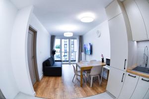 a small kitchen and dining room with a table and chairs at Elegant Two-Room Apartment, Sleeps 4, Near Turon Arena, Balcony ,Air condition in Kraków +17 photos