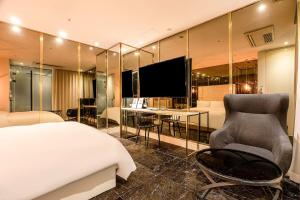 a bedroom with a bed and a desk and a television at Hotel The Designers Cheongnyangni in Seoul