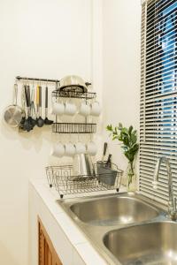 a kitchen with a sink and a dish rack over the sink at Ombra House No20 in Chiang Mai +48 photos