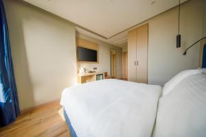 a bedroom with a white bed and a television at The Palm Bosphorus Hotel in Istanbul +37 photos