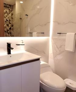 a white bathroom with a toilet and a sink at AH/Loft natural, Coworking, terraza+Gym, Usaquén in Bogotá +35 photos