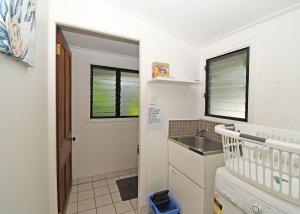 a small kitchen with a sink and a laundry room at Crab Shack on Moreton in Toogoom +26 photos