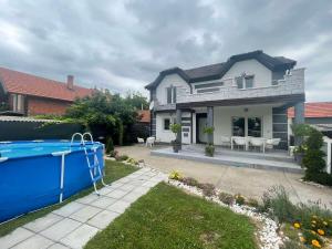 a house with a swimming pool in front of it at Vila city in Bijeljina