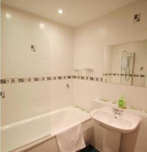 a bathroom with a sink and a tub and a toilet at Apartments Royal in Edinburgh
