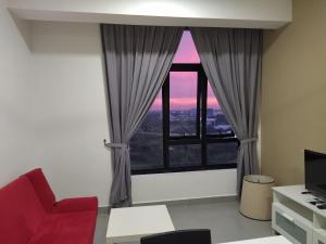 a living room with a red chair and a large window at Mayzi Holiday Home @ Cyberjaya in Cyberjaya