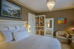 a bedroom with a large white bed and a chair at 254 South Union Street Guest House in Burlington