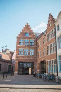 un edificio de ladrillo con bicicletas estacionadas frente a él en De Draecke Hostel en Ghent